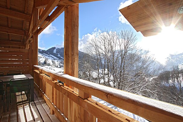 A balcony with a view of snow covered trees and mountains
