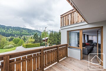 A balcony view of a forest under a cloudy sky.