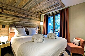 A hotel room with a bed and a chair