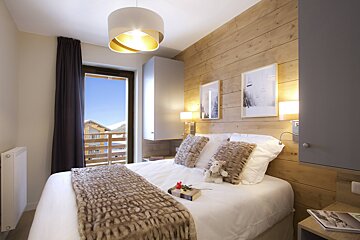 A bedroom with a large bed and a window
