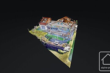 A 3D photogrammetry model of a rustic, multi-level house with green shutters and surrounding property, set against a dark background.