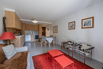 A living room with a table and chairs and a lamp