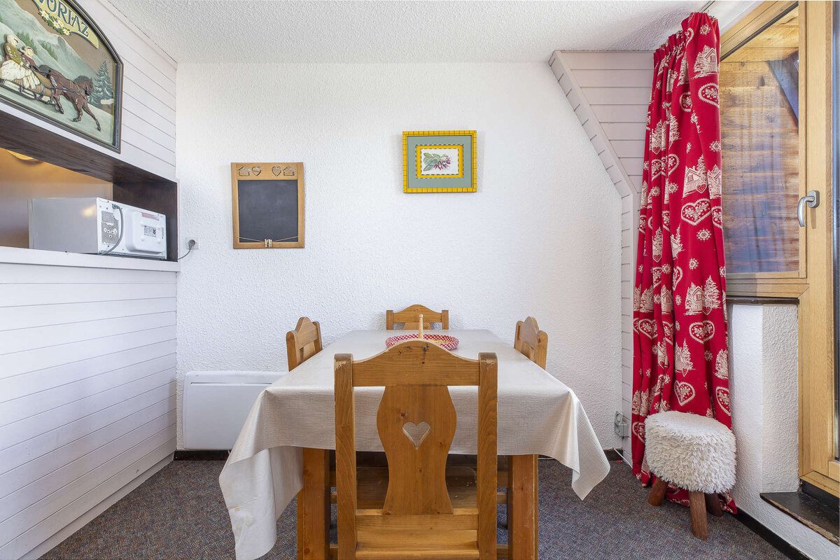 A dining room with a table and chairs and a chalkboard with the numbers 97 96 on it