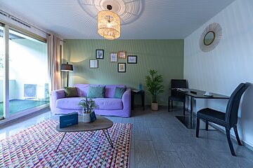 A living room with a purple couch and a table