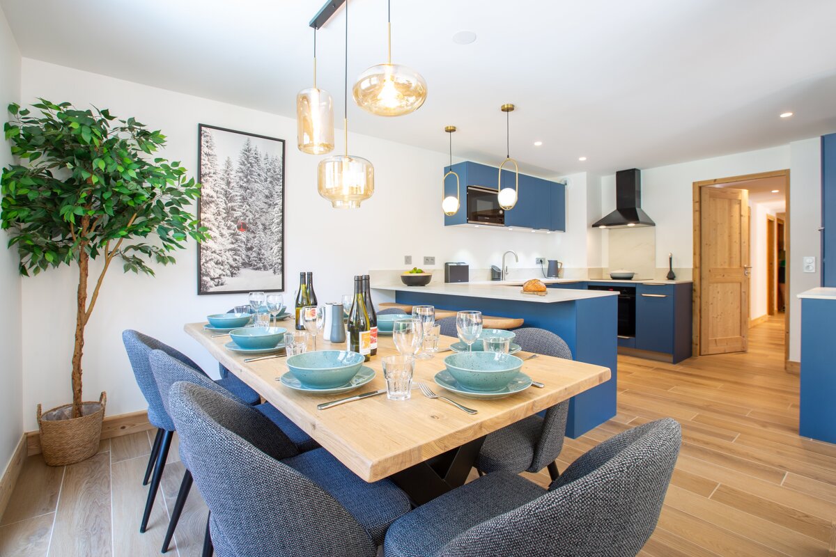 A dining room table with a bottle of wine on it