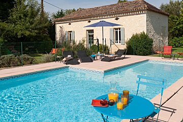 A swimming pool with a table and chairs in front of it
