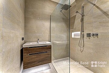 A bathroom with a walk in shower by mountain base