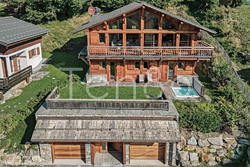 An aerial view of a large wooden house with a hot tub
