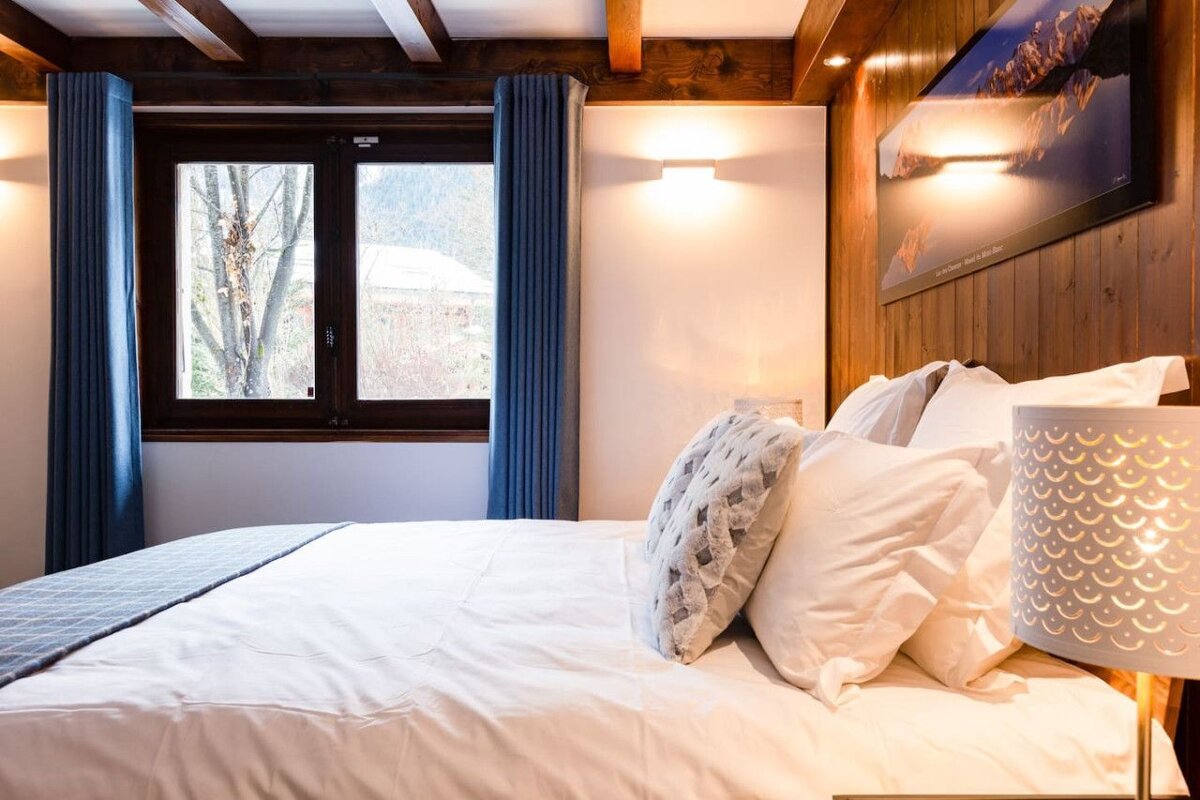 A bedroom with a bed and a picture of a mountain on the wall