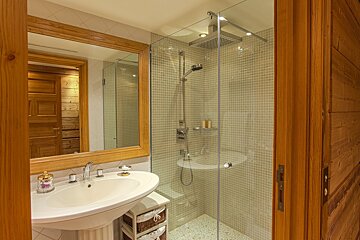 A bathroom with a sink and a walk in shower
