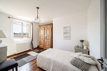 A bedroom with a bed and a painting on the wall