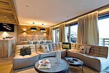 A living room with a couch and a table with a bottle of champagne on it