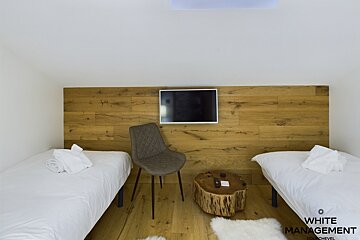 A snowy hillside with trees and a building in the background