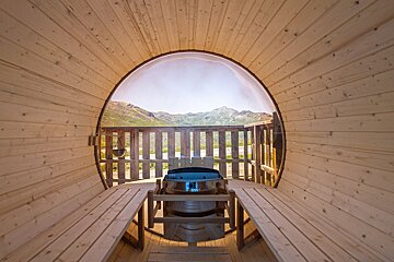 A wooden sauna with a view of the mountains