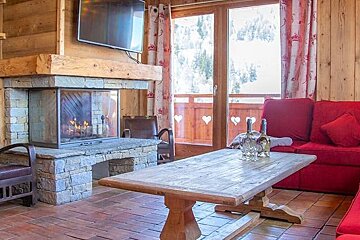 A living room with red couches and a fireplace