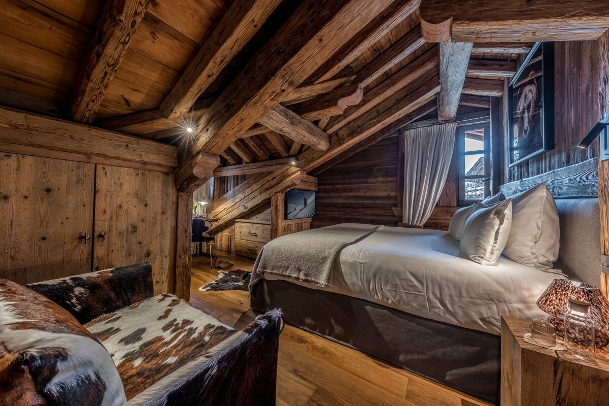 A bedroom with a cowhide blanket on the bed