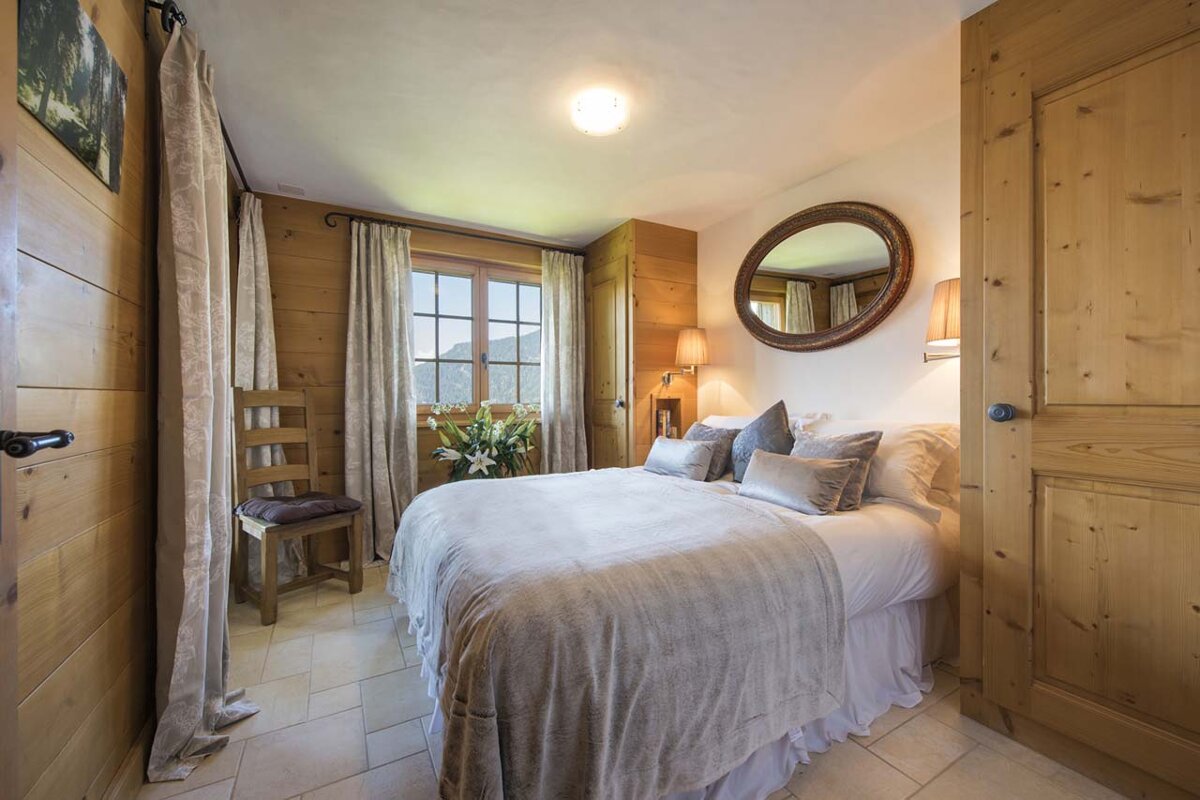 A bedroom with a bed and a mirror on the wall