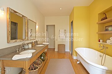 A bathroom with two sinks and a bathtub and the words made in provence on the wall