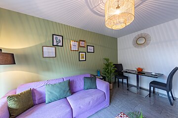 A living room with a purple couch and a table
