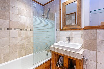 A bathroom with a bathtub sink and mirror