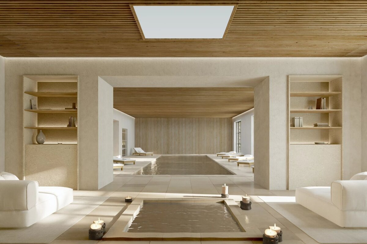 Luxurious indoor spa featuring two tranquil pools, a slatted wooden ceiling, minimalist decor, lounge chairs, and soft candlelight.