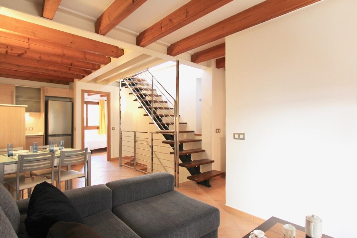 A living room with a staircase leading up to the second floor