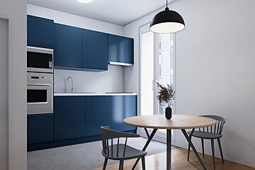 Stylish modern kitchen with navy blue cabinets, white counters, and a round wood dining table by a large window.