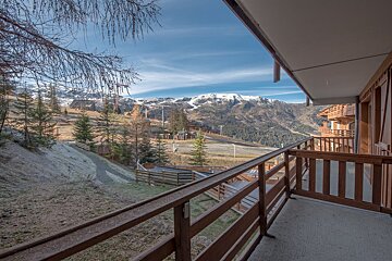A balcony with a view of mountains and trees