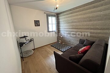 A room with a couch and a printer and the website chximmobilier.com