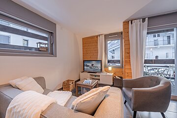 A living room with a couch a chair and a flat screen tv