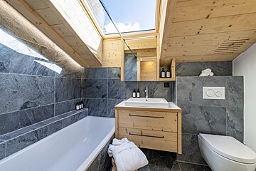 A bathroom with a skylight above the bathtub