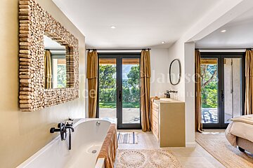 A bathroom with a bathtub and a mirror with the word jause on it