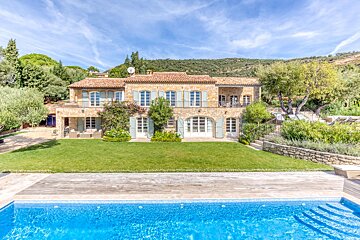 A large house with a swimming pool in front of it