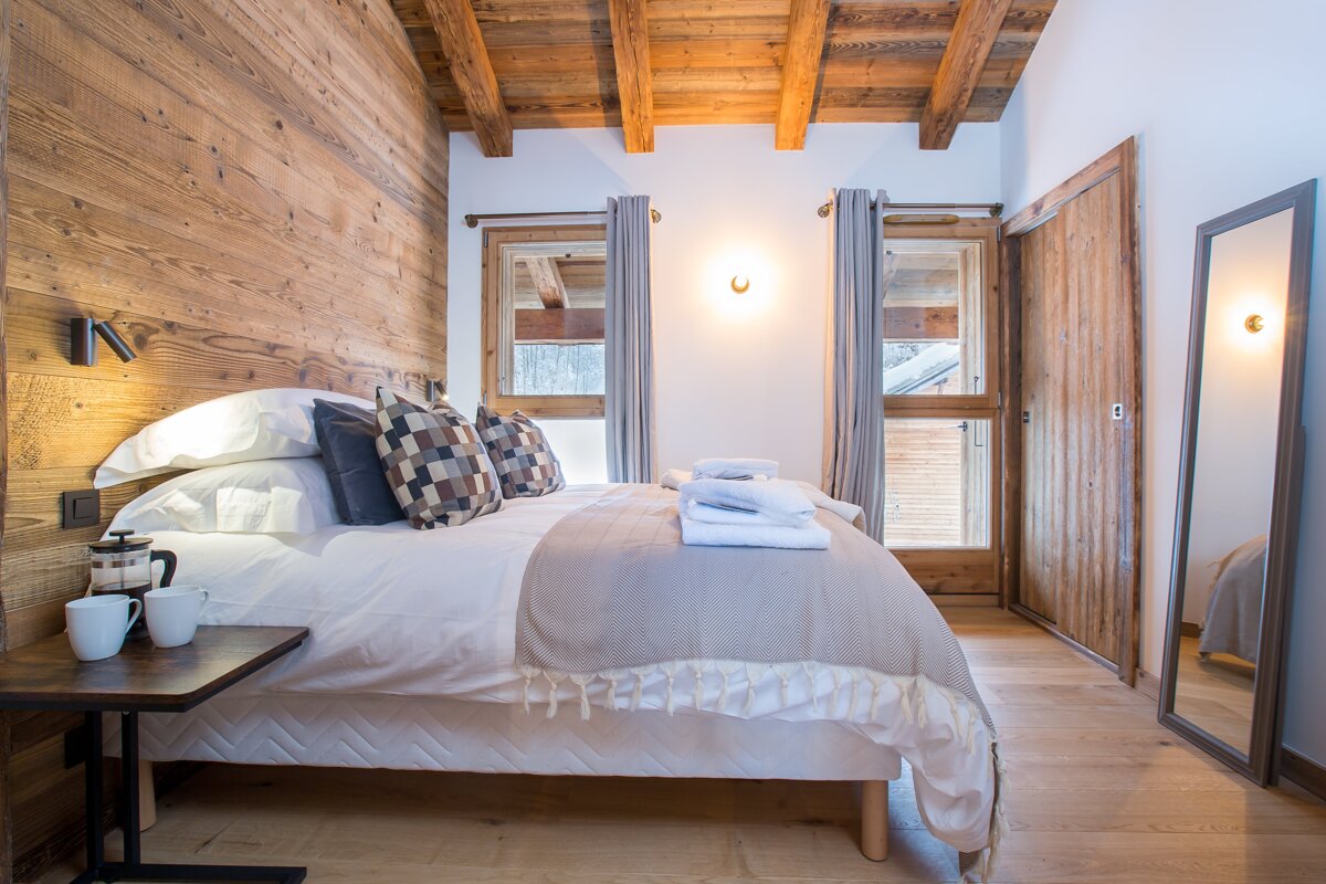 A bedroom with a large bed and a mirror