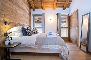 A bedroom with a large bed and a mirror