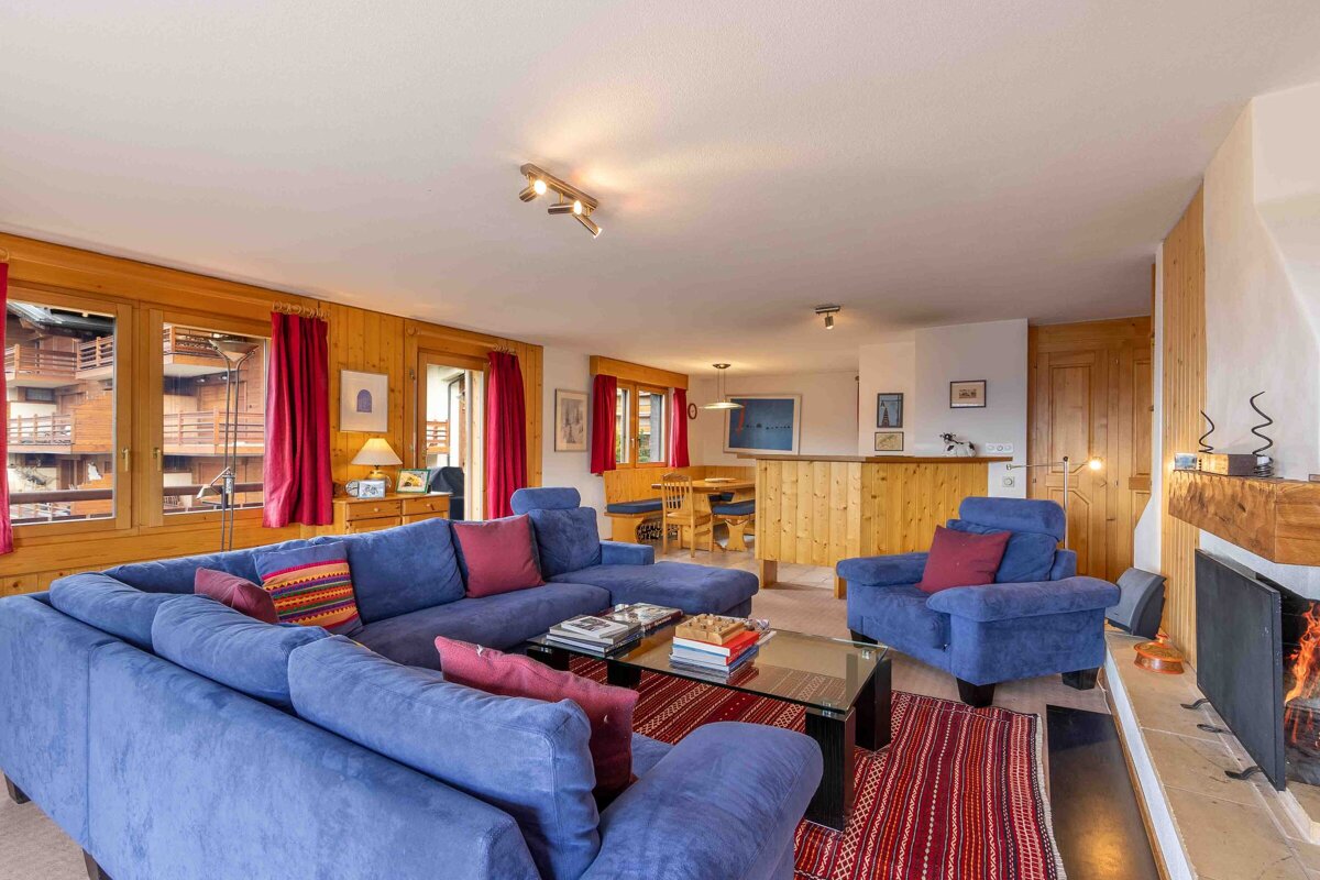 A living room with blue furniture and a fireplace
