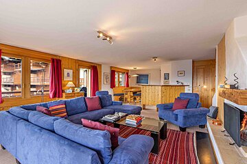 A living room with blue furniture and a fireplace