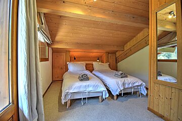 A bedroom with two twin beds and a mirror