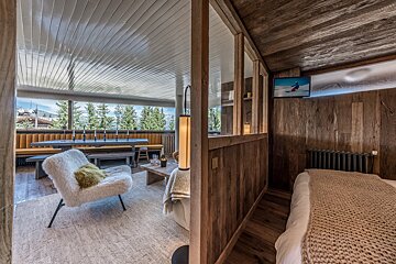 A room with a chair and a television that shows a person skiing