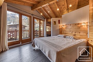 A bedroom with a bed and a sign that says alpine-property