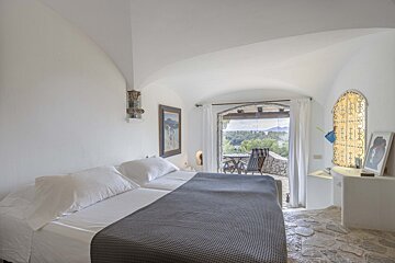 A bedroom with two beds and a painting on the wall