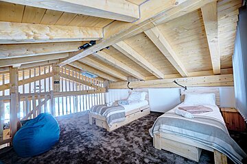 A bedroom with two beds and a blue bean bag chair