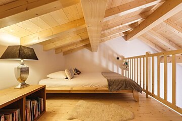 An attic bedroom with a bed and a lamp