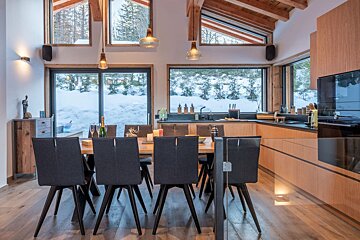 A kitchen with a table and chairs and a view of snow