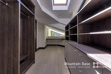A walk in closet with a skylight and a sign that says mountain base