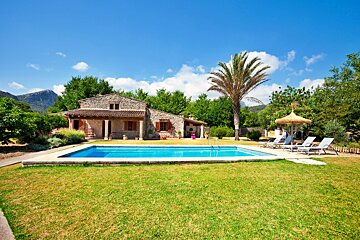 A house with a large swimming pool in front of it