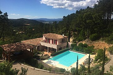 A large house with a swimming pool in front of it