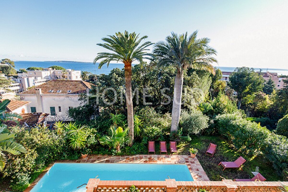 An aerial view of a swimming pool surrounded by palm trees with the word home on the bottom