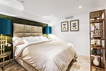 A bedroom with a bed and two framed butterflies on the wall