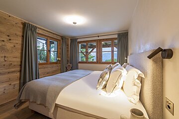 A bedroom with a large bed and a window